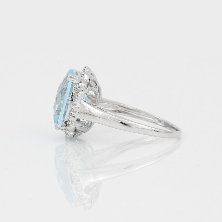 RING, 18K vitguld med chequerslipad blå topas, ca 5,23 ct, diamanter tot ca 0,20 ct. Vikt ca 4,17 g.