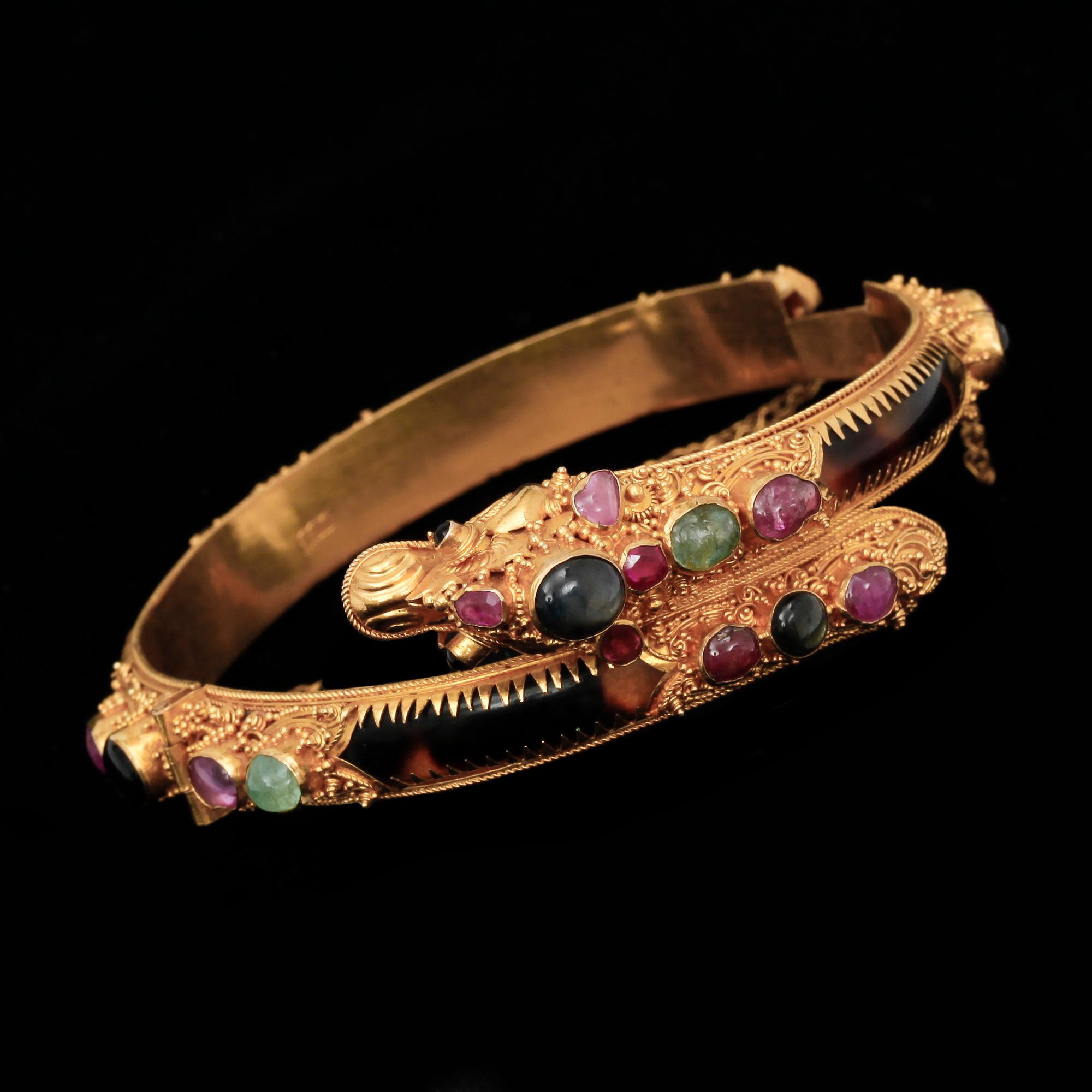 ARMBAND, 22k guld med flertal trumlade ädelstenar, bla. rubiner och smaragder. Vikt 26,9 g.