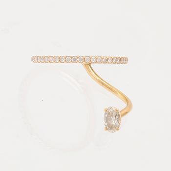 An 18K gold ring set with an oval cut and round brilliant cut diamonds by LWL Jewelry.