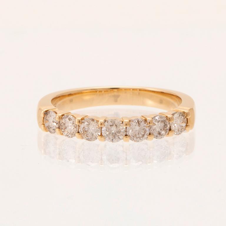 An 18K gold half-eternity ring set with round brilliant-cut diamonds.