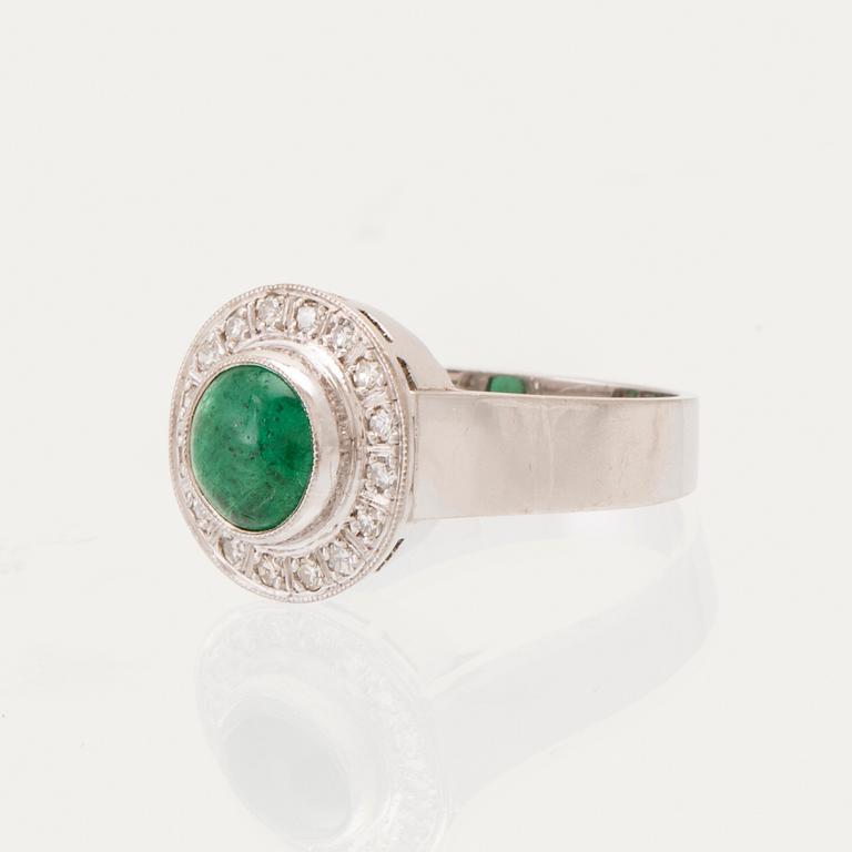 An 18K white gold ring set with a cabochon-cut emerald and round single-cut diamonds.