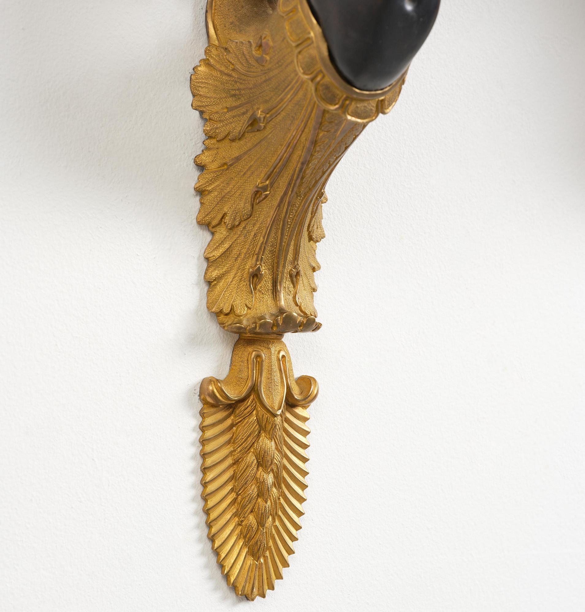A pair of Napoleon III five-branch gilt and patinated bronze appliques.