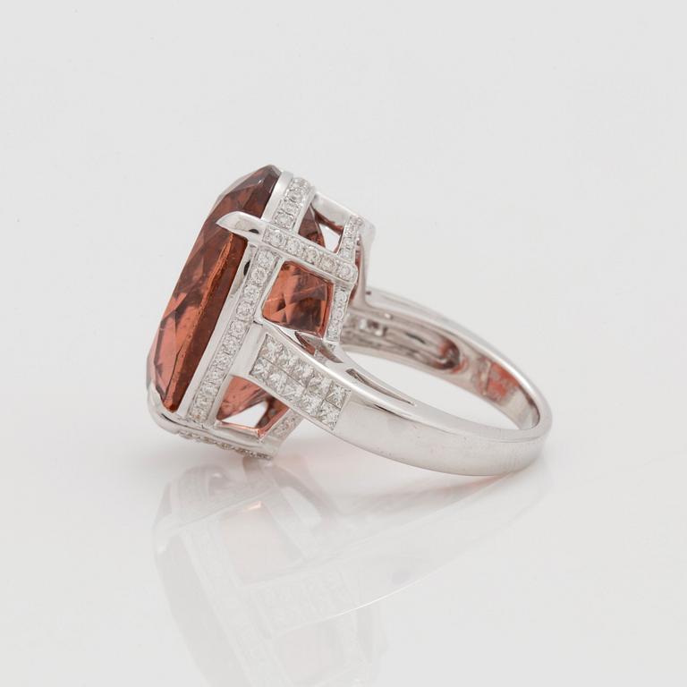 A circa 30.40 ct orange tourmaline and diamond ring. Total carat weight of diamonds circa 1.25 cts.