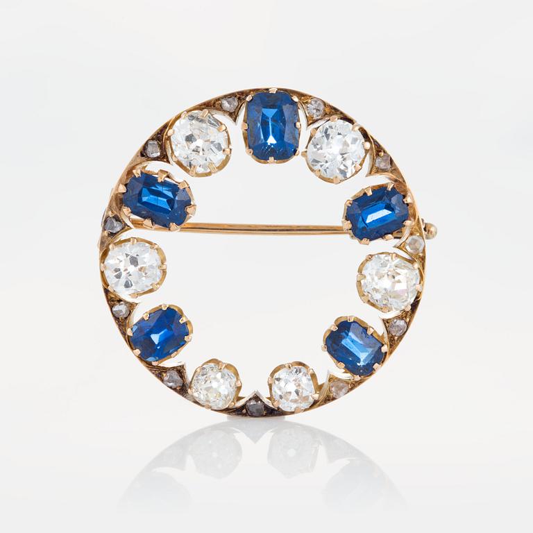 A brooch in 14K gold set with old- and rose-cut diamonds and faceted sapphires.