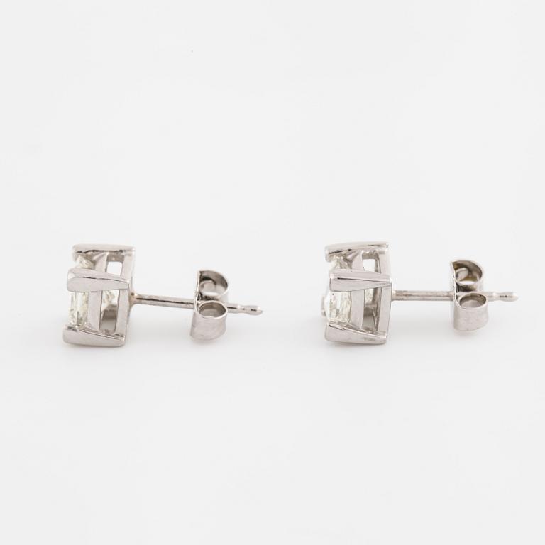 A pair of princess cut diamond earrings.