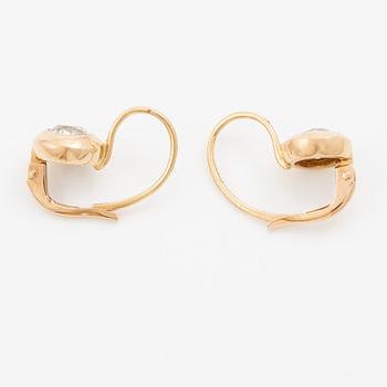 A pair of earrings in 18K gold set with two old-cut diamonds.