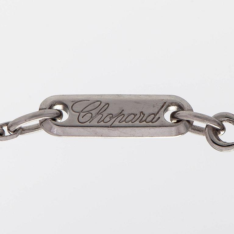 Chopard, an 18K whitegold 'Happy Diamonds" cross necklace set with diamonds.