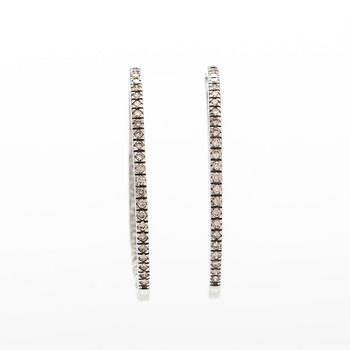 A pair of 14K white gold  hoop earrings with diamonds.