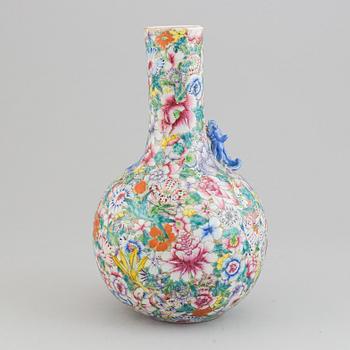 A chinese globular shaped vase, richly decorated with flowers and a dragon and a bat, second half of the 20th century.