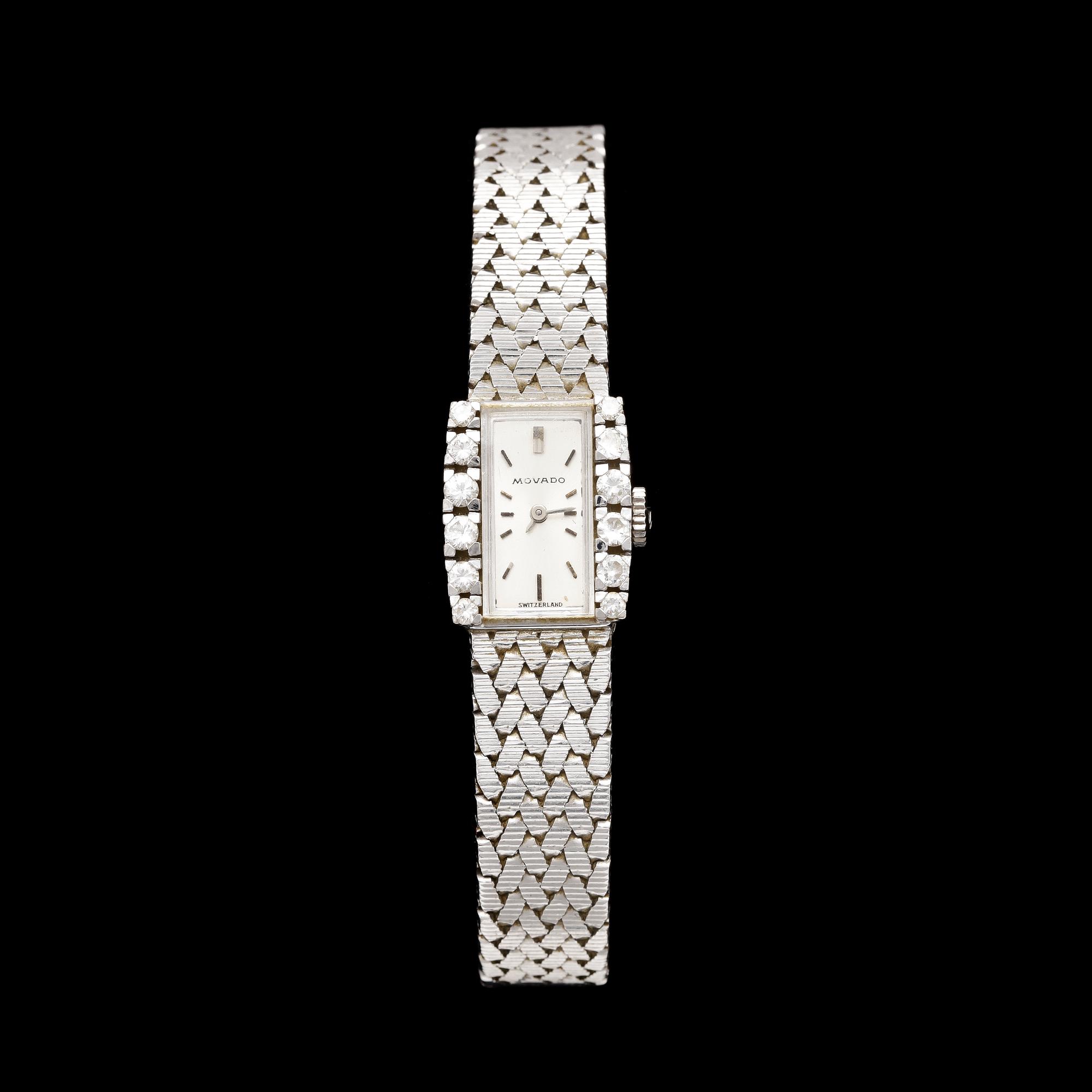 DAMARMBANDSUR, 18k vitguld med 12 briljantslipade diamanter, Movado. Tot ca 39 g.