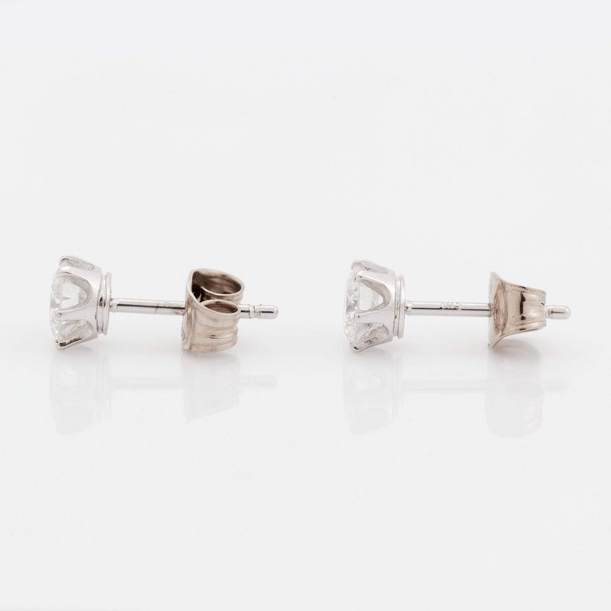 A pair of 18K white gold earrings set with two round brilliant-cut diamonds.