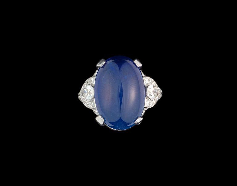RING, cabochonslipad blå safir, 14.37 ct med briljantslipade diamanter, tot. ca 1.30 ct. Cert. GRS.