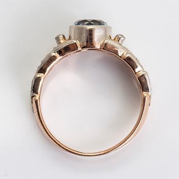 A 14K gold ring with diamonds ca. 0.18 ct in total, and a topaz.