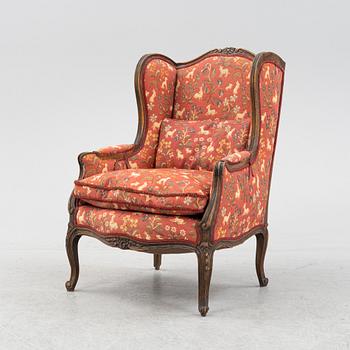 A Louis XV style easy chair from around the year 1900.