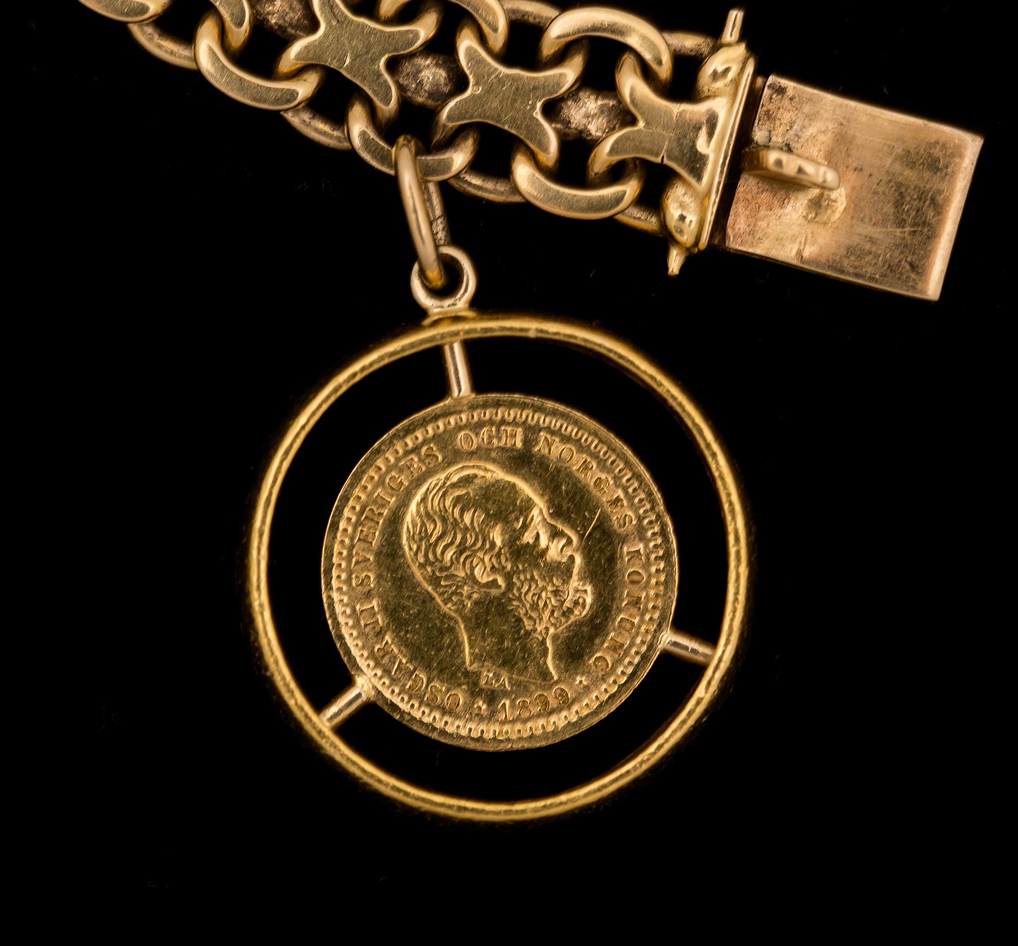 ARMLÄNK, 18 k guld med berlock i form av ett mynt. Vikt ca 34 g.
