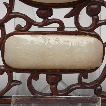 A set of four carved nephrite objects on a wooden frame, Qing dynasty (1664-1912).