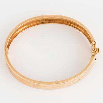 An 18K gold bangle.