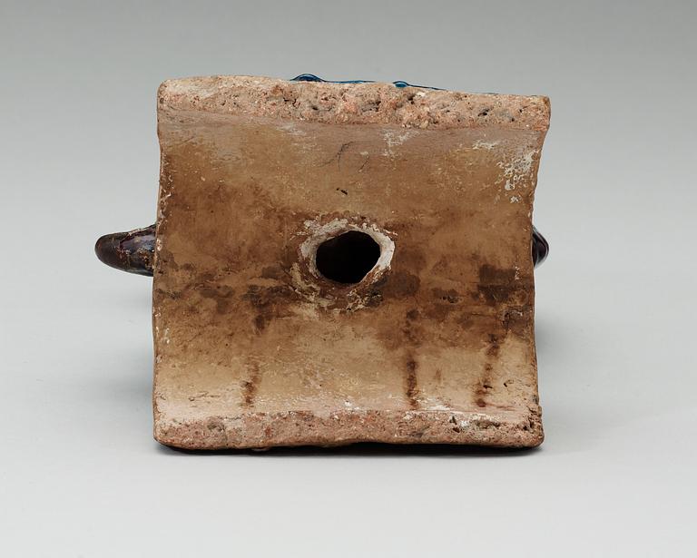 A turquoise and purple glazed roof top tile in the shape of a fish, Ming dynasty.