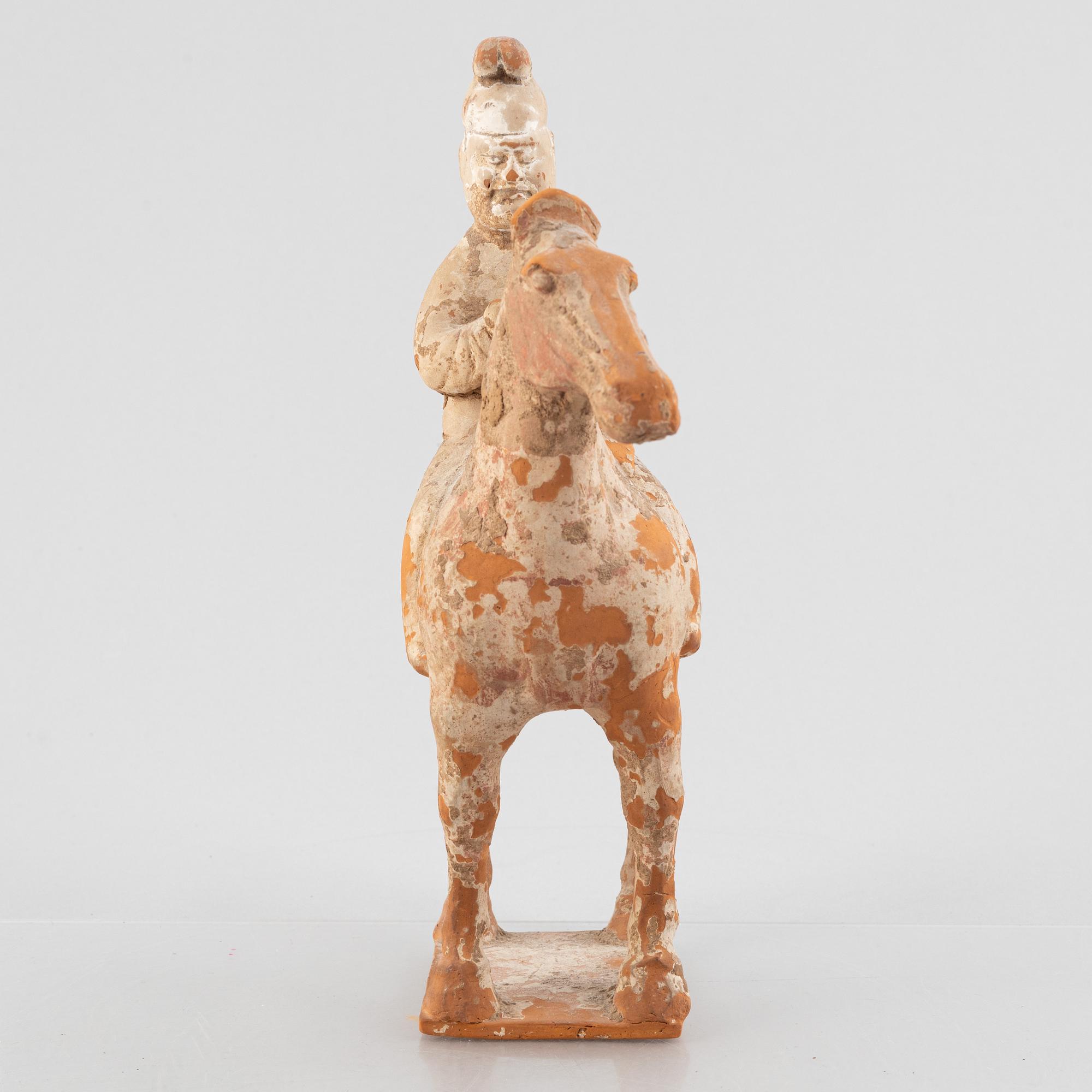 A painted pottery figure of an equestrian standard-bearer, Tang dynasty (618-907 AD.).