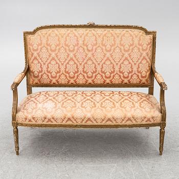 A pair of Louis XVI-style armchairs and a sofa, 20th century.