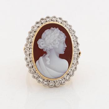 An 18K gold ring set with a hardstone cameo.