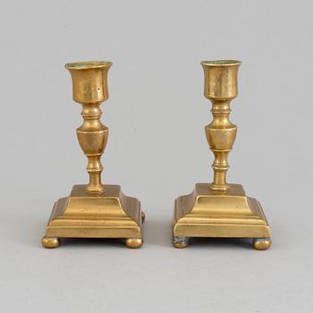 A pair of brass candlesticks, 18th Century.