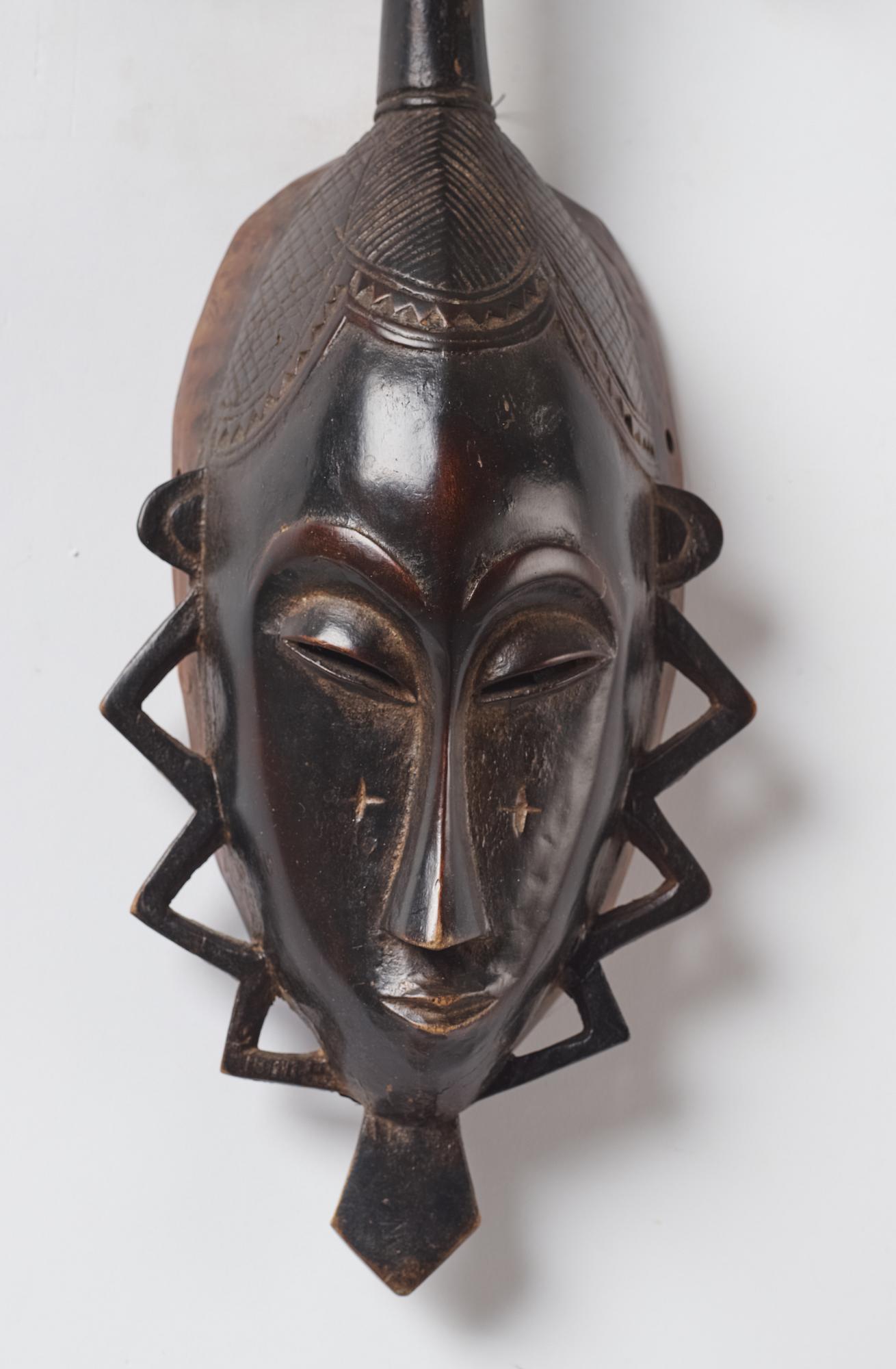 A sculptue and two masks reportedly from The Ivory coast, from the second half of the 20:th century.
