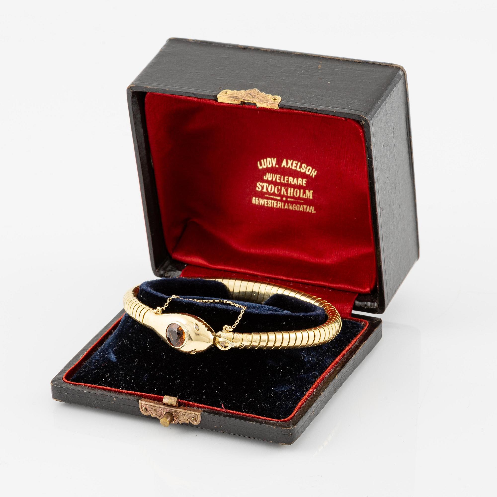 A bracelet in the shape of a serpent in 18K gold with a faceted citrine and rose-cut diamonds.