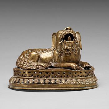 589. A copper alloy figure of a reclining buddhist lion, presumably 18th Century.