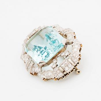 A platinum brooch set with an aquamarine and round brilliant- and eight-cut diamonds.