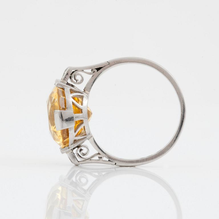 A circa 13.50 ct fancy yellow sapphire and brilliant-cut diamond ring. Total carat weight of diamonds circa 0.10 ct.