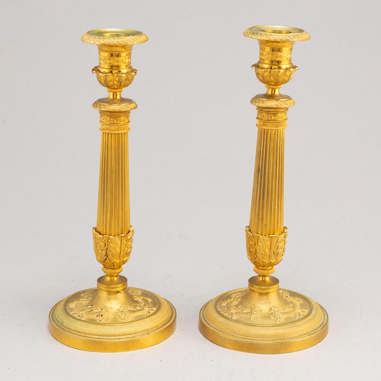A pair of first half of the 19th century Empire candel sticks, gilded bronze, first half of the 19th century.