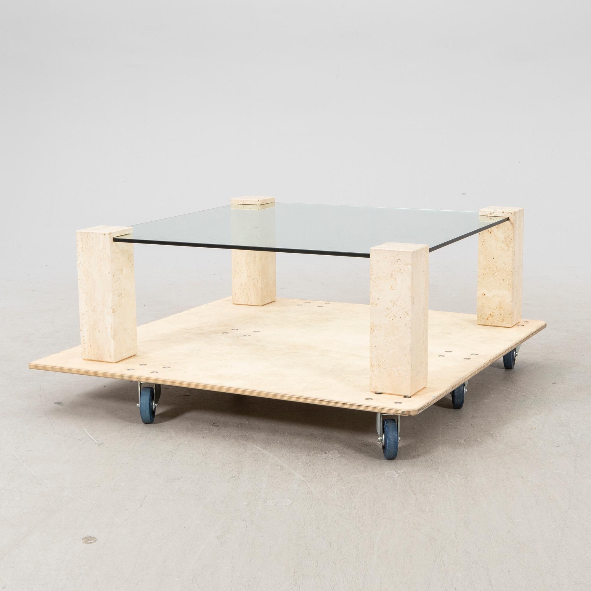 A late 20th century glass and travertin coffee table.