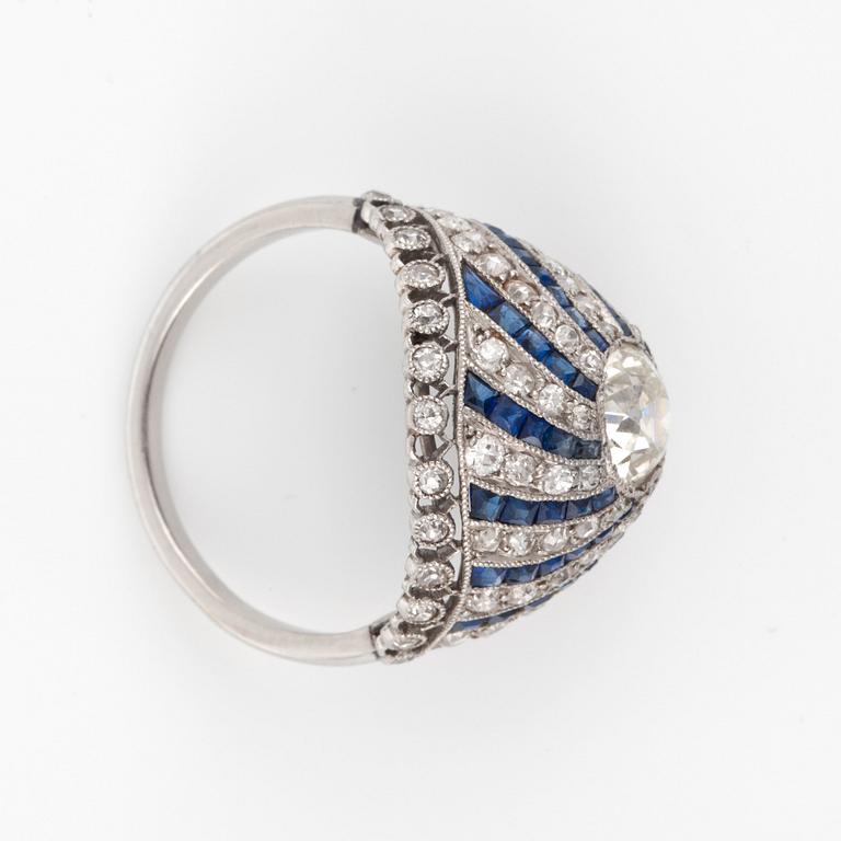 A 'spinning wheel' sapphire and diamond ring. Circa 1930. French hallmarks. Platinum. Size 16.50/52. Weight circa 5 g.