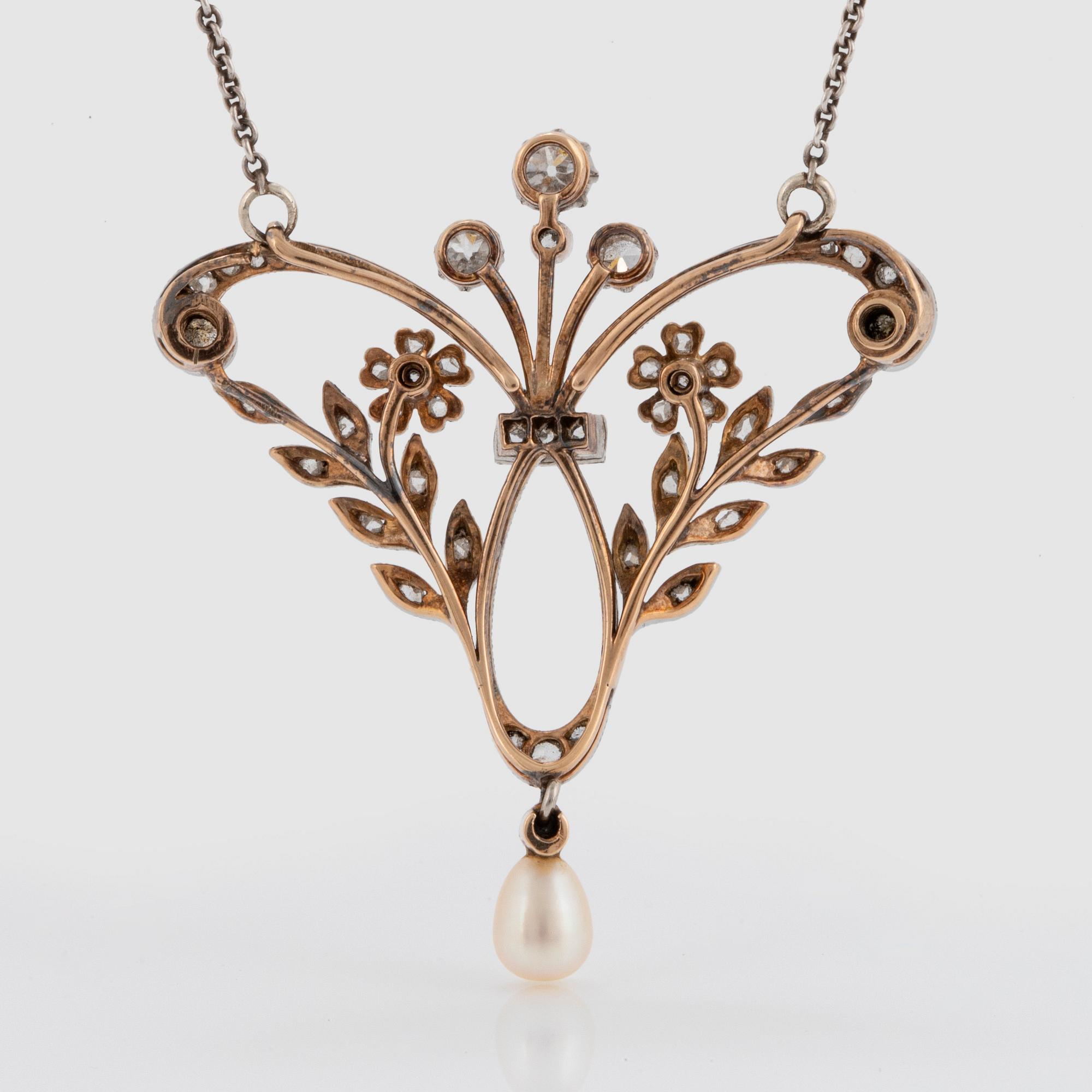 A pendant/brooch in 14K gold and platinum set with old- and rose-cut diamonds and a pearl.