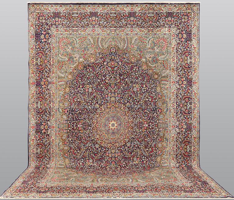 A Kirman Laver carpet, approx. 424 x 305 cm.