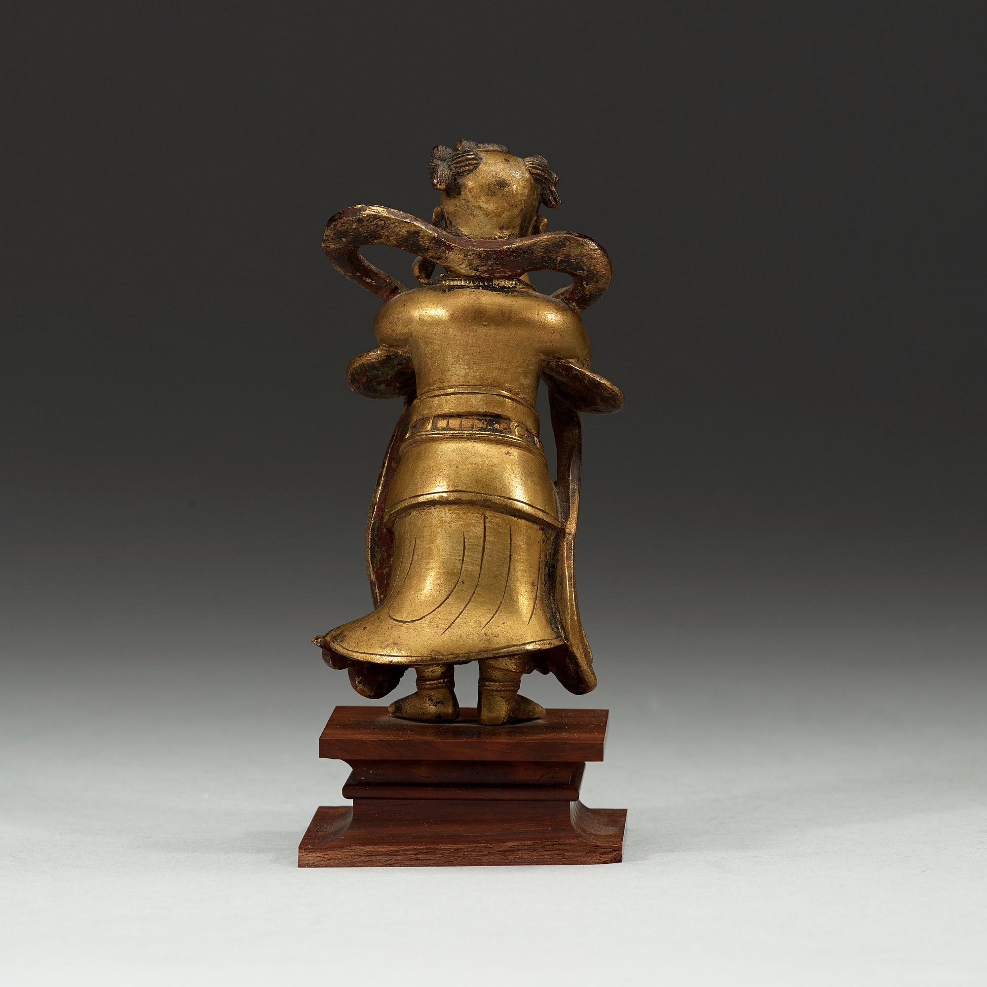 A gilt bronze figurine of a standing boy, Ming dynasty, 17th century.