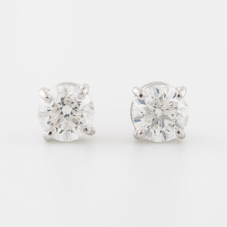 A pair of brilliant cut diamond earrings.