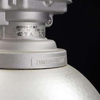 An industrial ceiling lamp marked Zumtobel Staff.