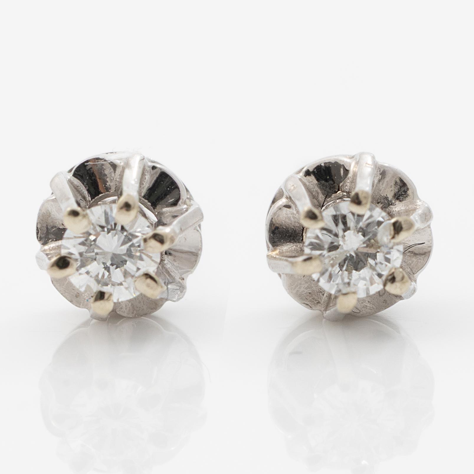 A pair of 18K white gold earrings with round brilliant-cut diamonds.