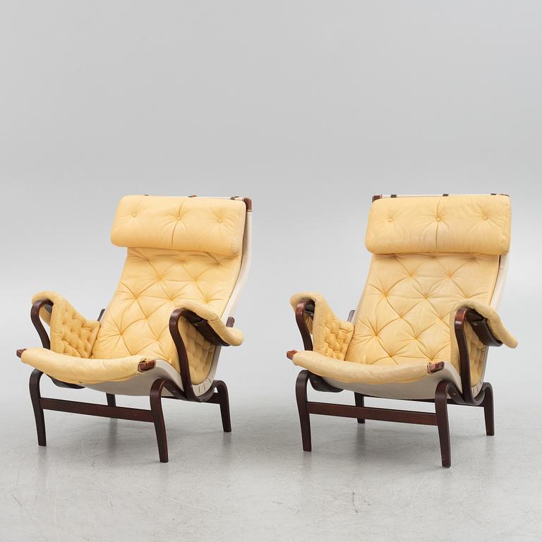 Bruno Mathsson, a pair of "Pernilla" armchair with ottoman, Dux, Sweden, second half of the 20th century.