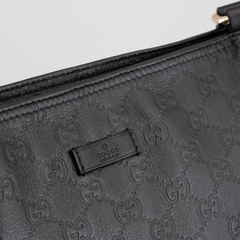 Gucci, a leather messenger bag.