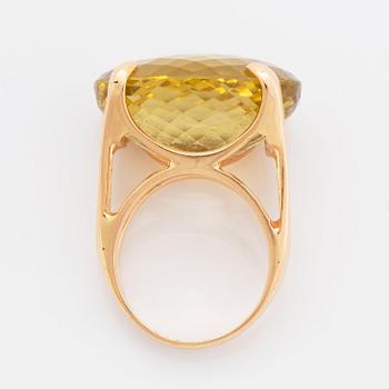 An 18K gold ring set with a faceted lemon quartz.