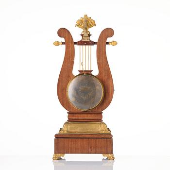 A French Empire mahogany, ormolu and gilt metal lyre-shaped mantel clock, early 19th century.