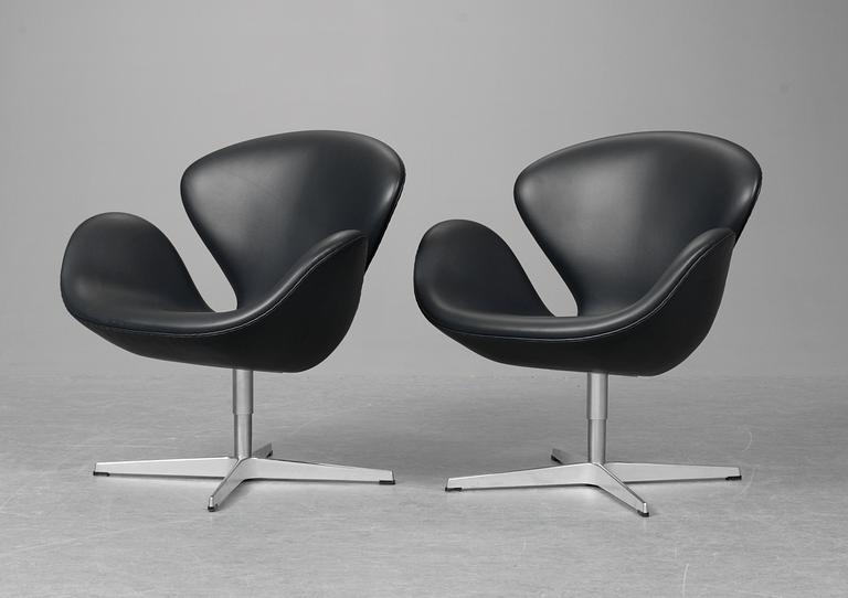 A pair of Arne Jacobsen dark grey leather "Swan Easy Chairs, Fritz Hansen, Denmark 2008.