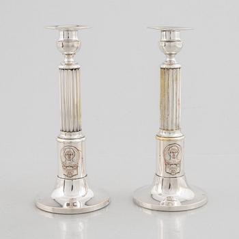 A pair of candlesticks and a commemorative pin from the Olympic Games in Stockholm 1912.