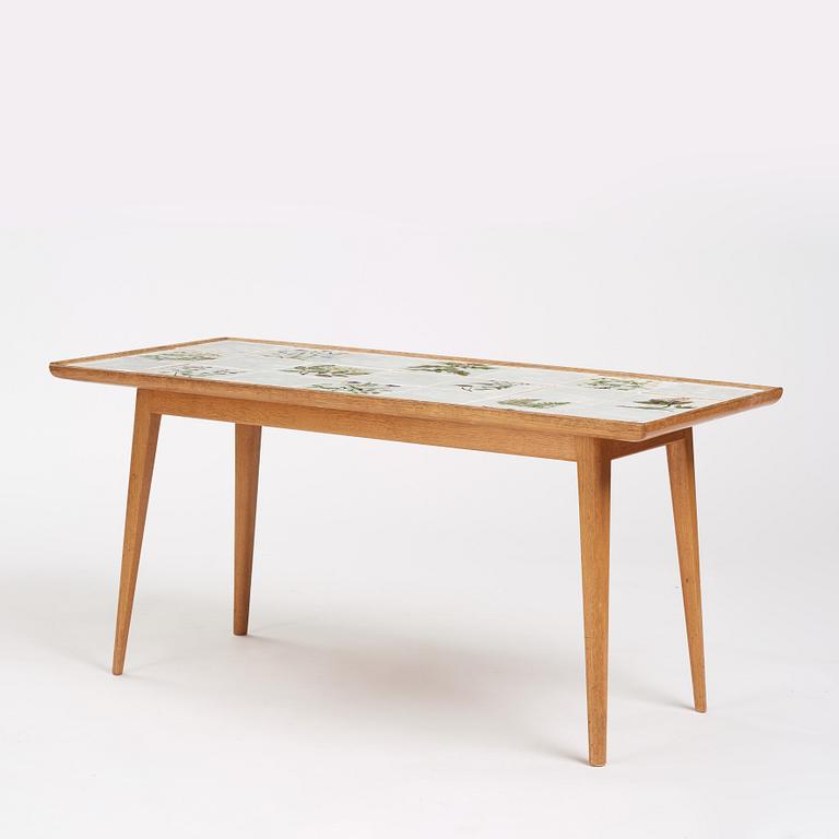 a Swedish Modern coffee table, decorated with Jobs' ceramic tiles, signed and dated 1941.