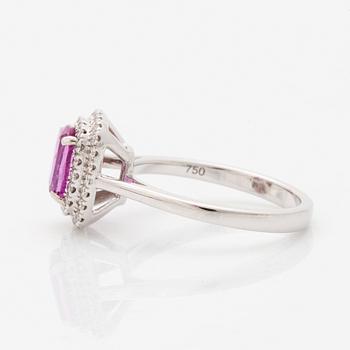 An 18K white gold ring set with a pink sapphire and round brilliant-cut diamonds.