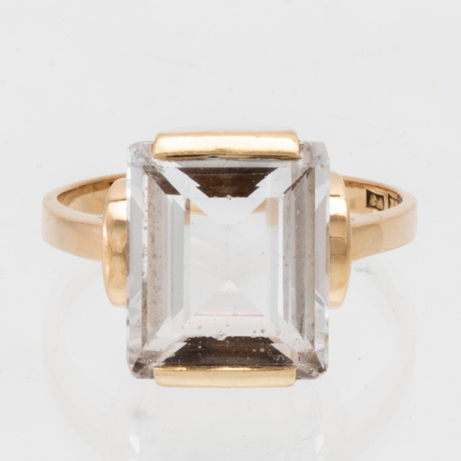 An 18K gold ring set with a step-cut synthetic white spinel.