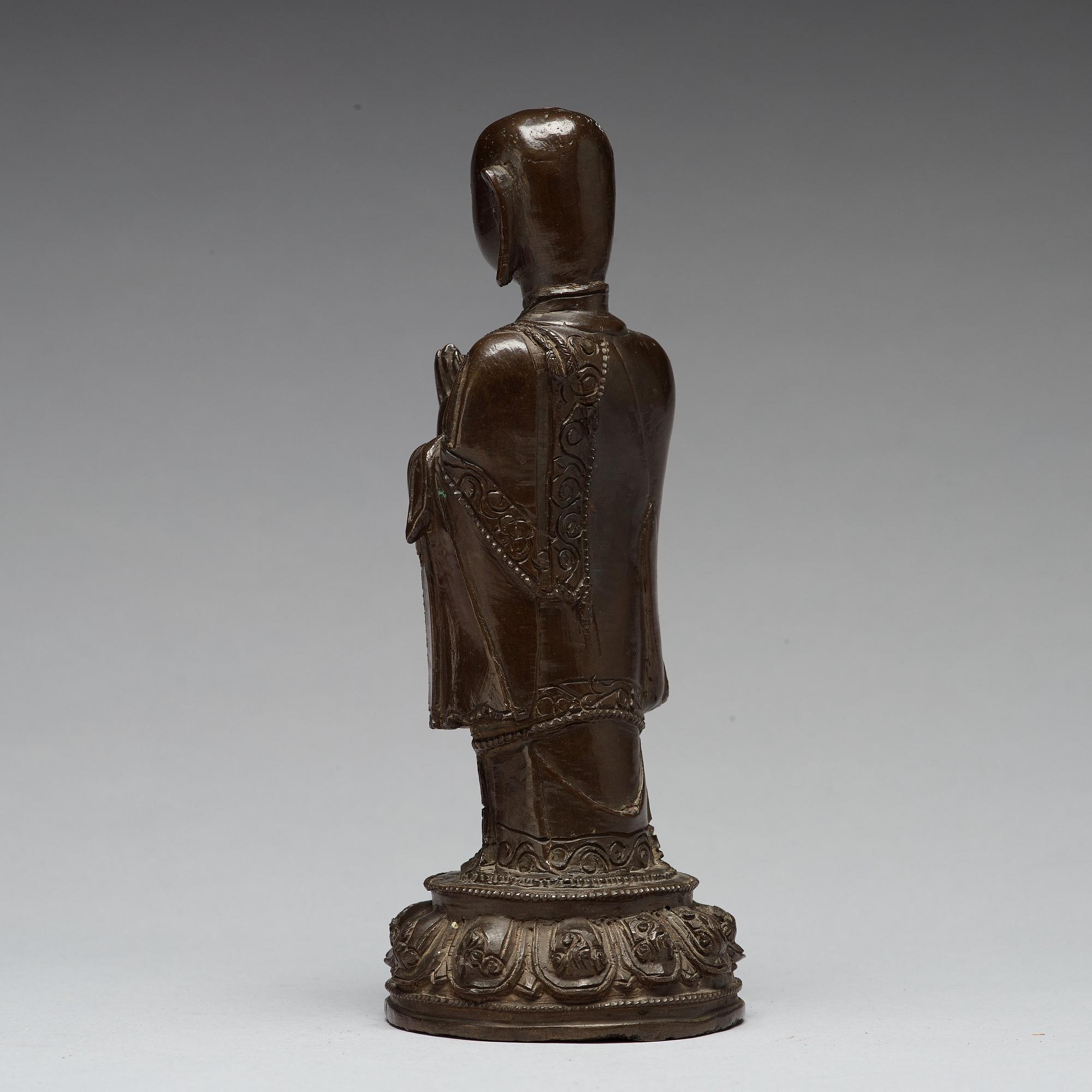 A bronze figure of a standing buddha, late Ming dynasty (1368-1644).